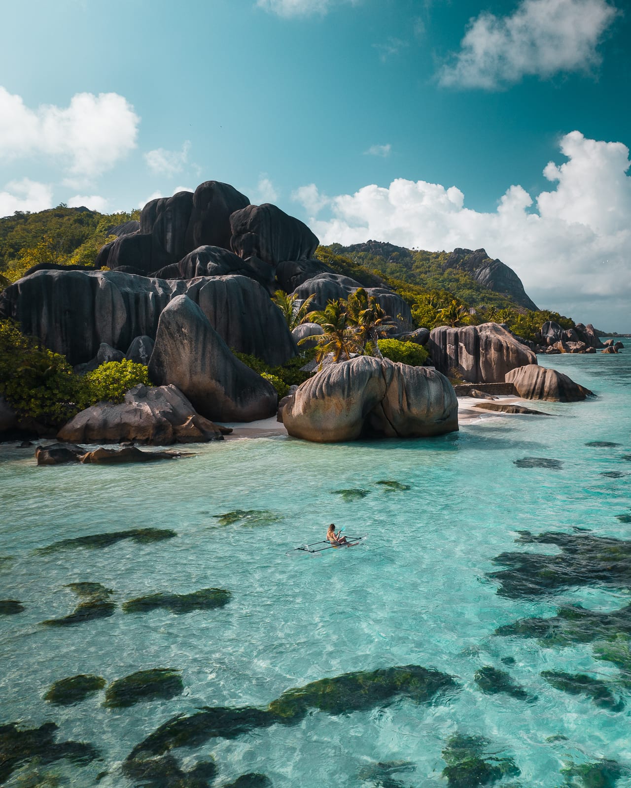 Aerial view of transparent kayak floating in clear blue water at Anse Sorce d'Argent beach in La Digue, Seychelles