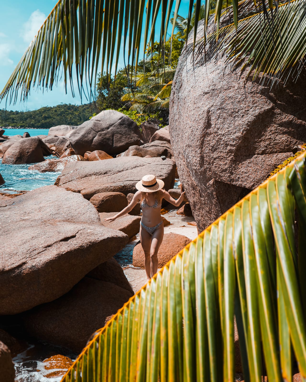 woman walking on a rocky beach in Praslin, Seychelles