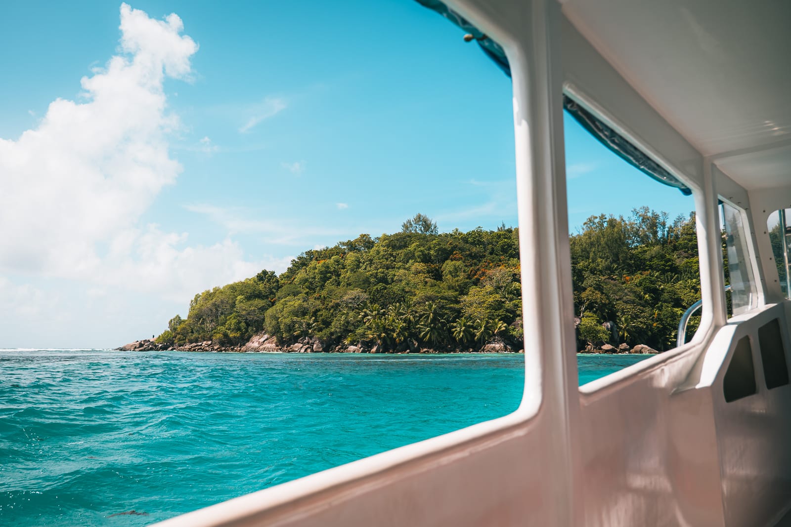 boat on turqoise water and view of jungle