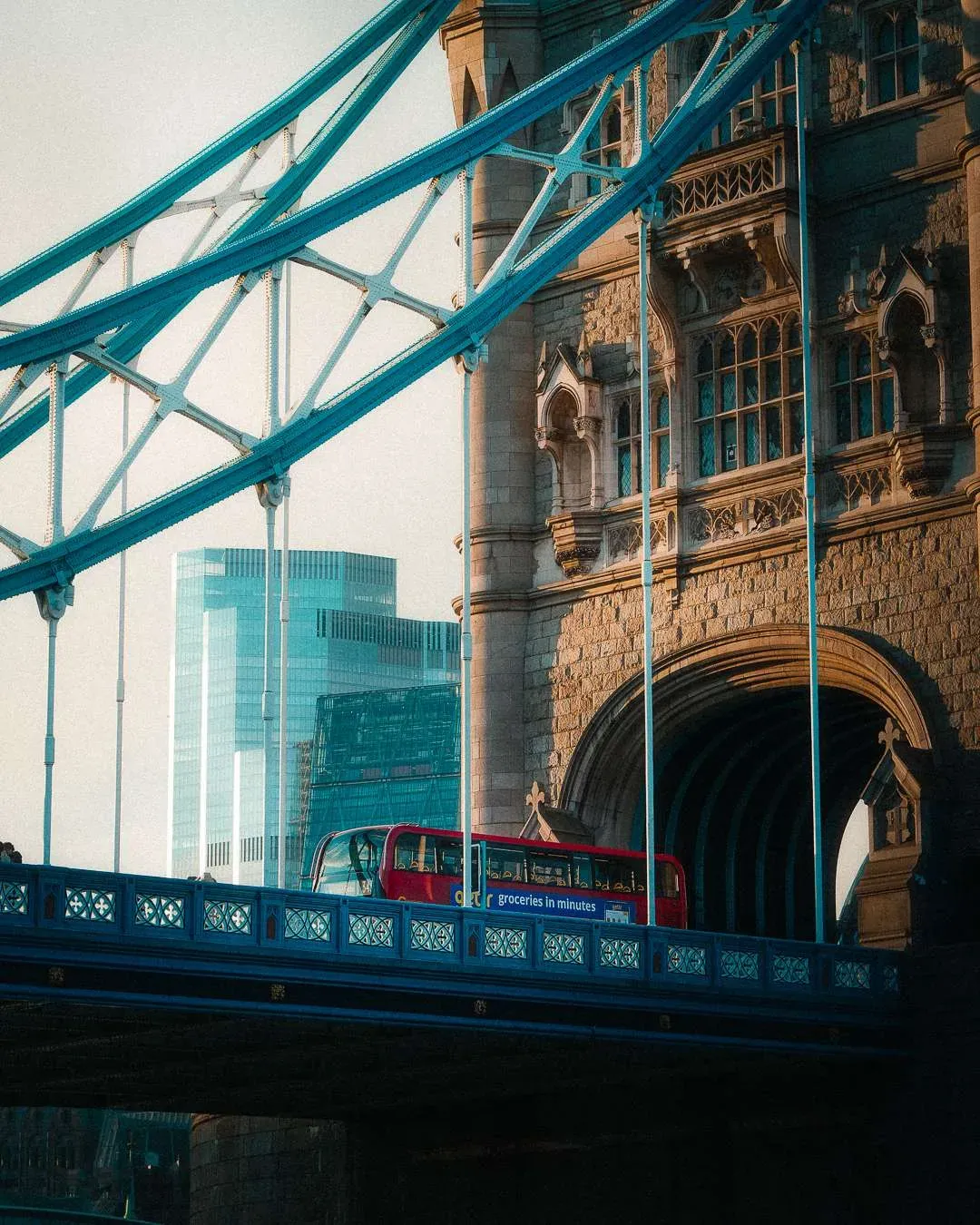 Close up of a red bus driving over Tower Bridge