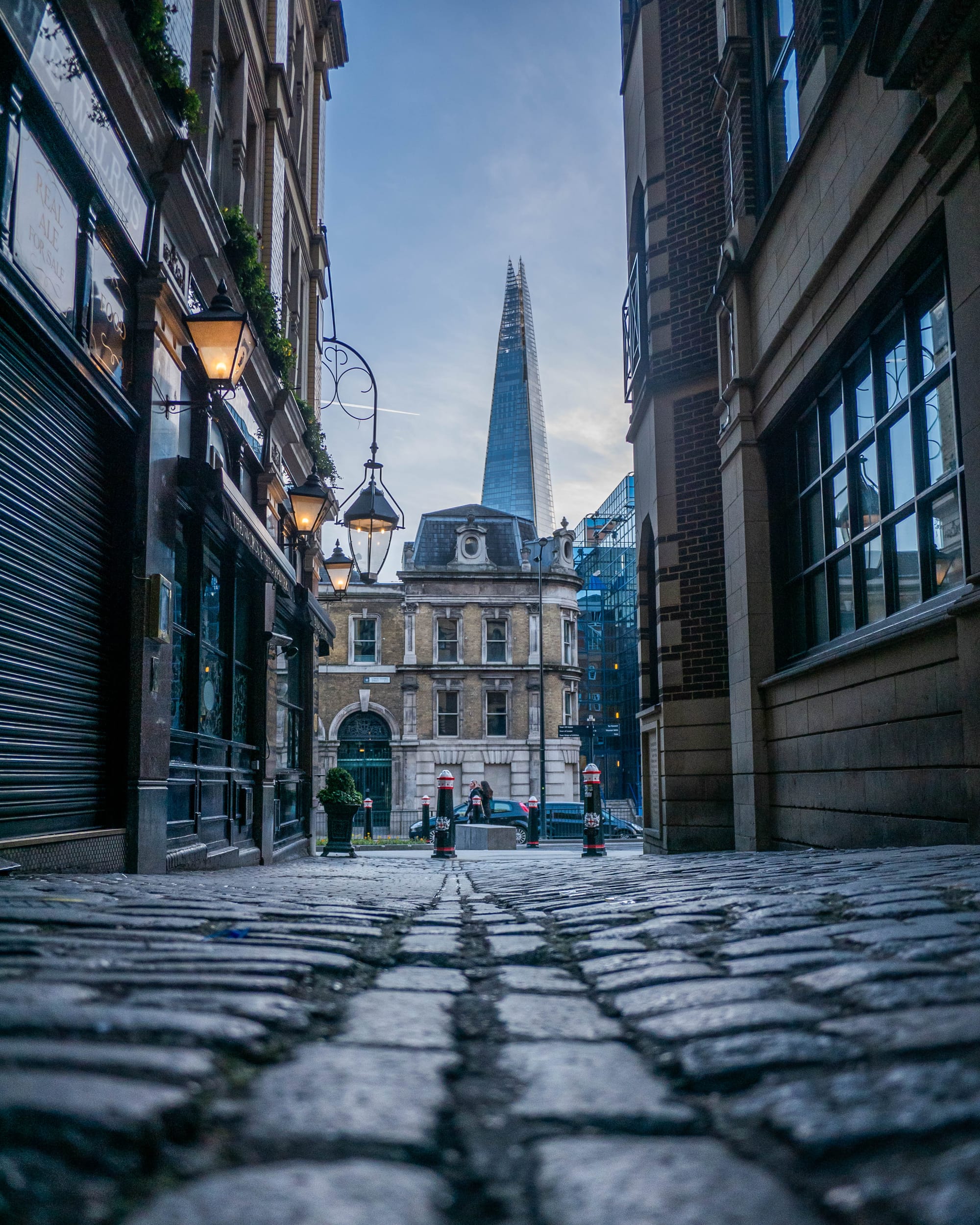 View of the Shard down an old cobbled strret on Lovat Lane, London