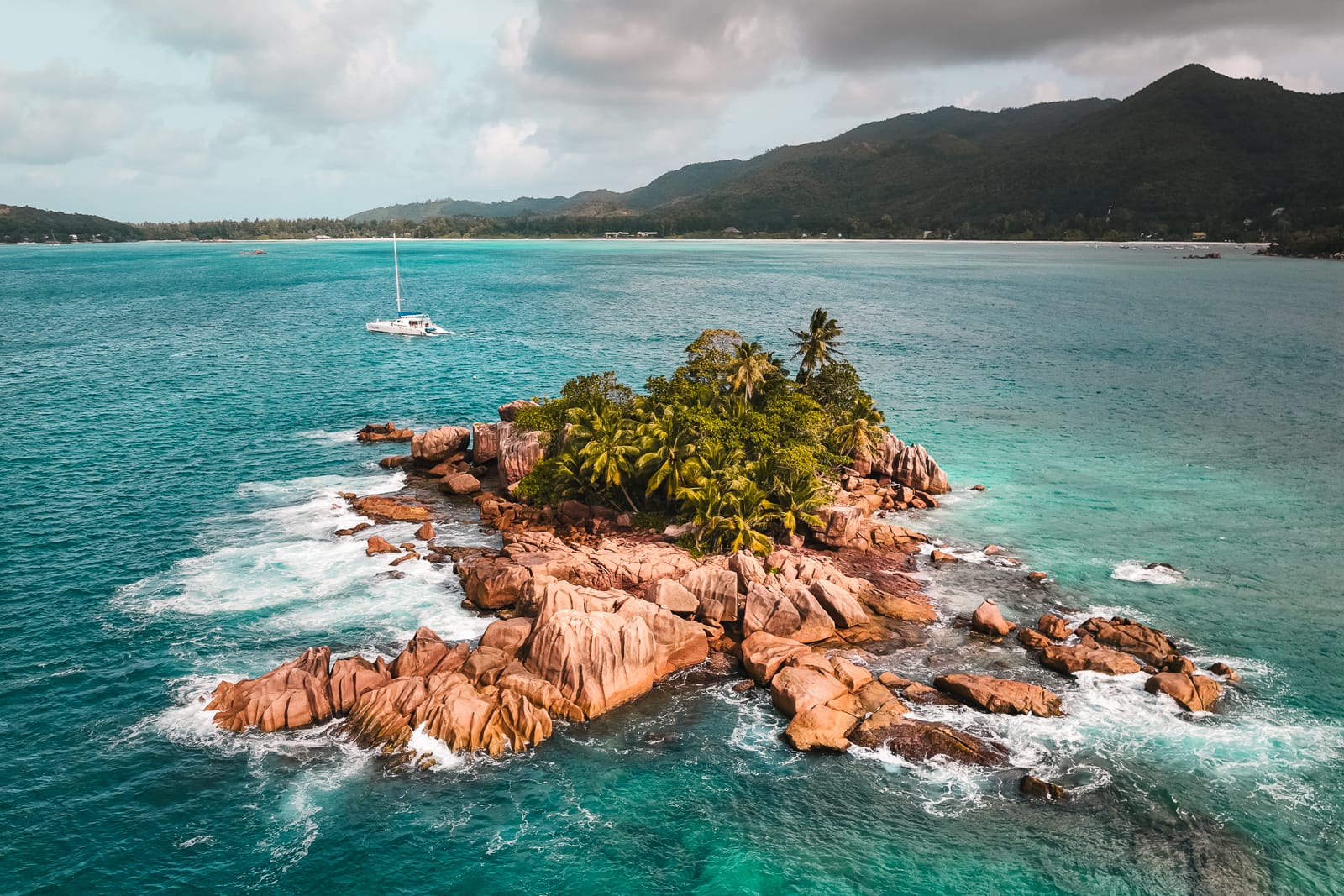 rocky islet with mountains in the background