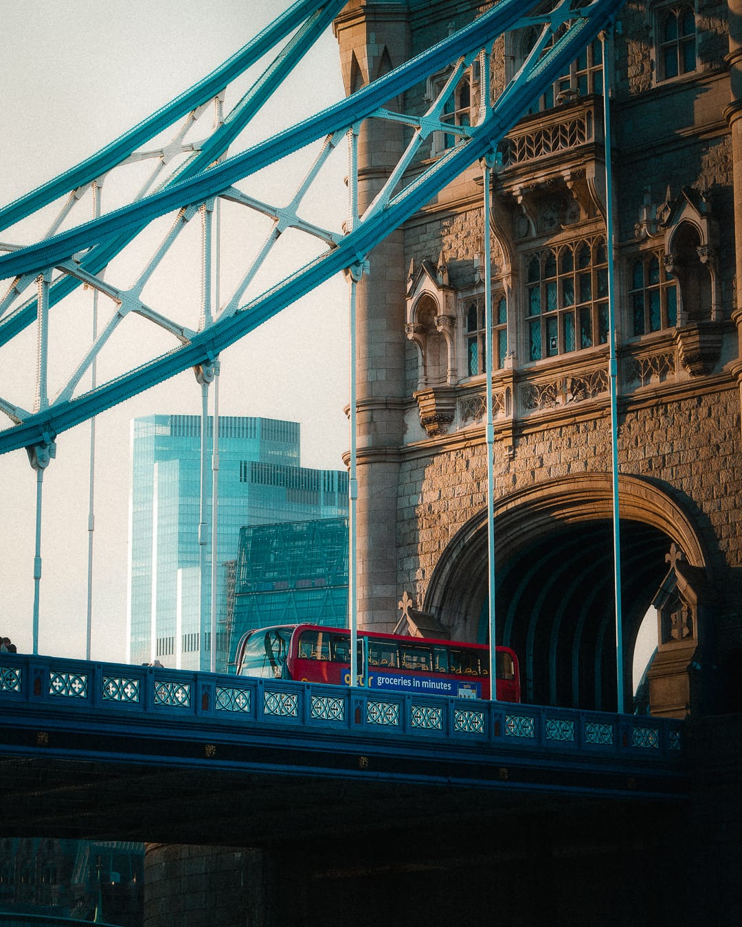 red london bus driving on tower bridge in london