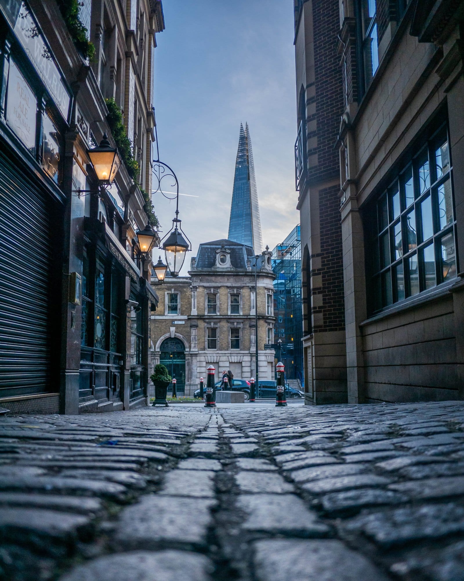 cobbled street with old lampost and the shard building in background