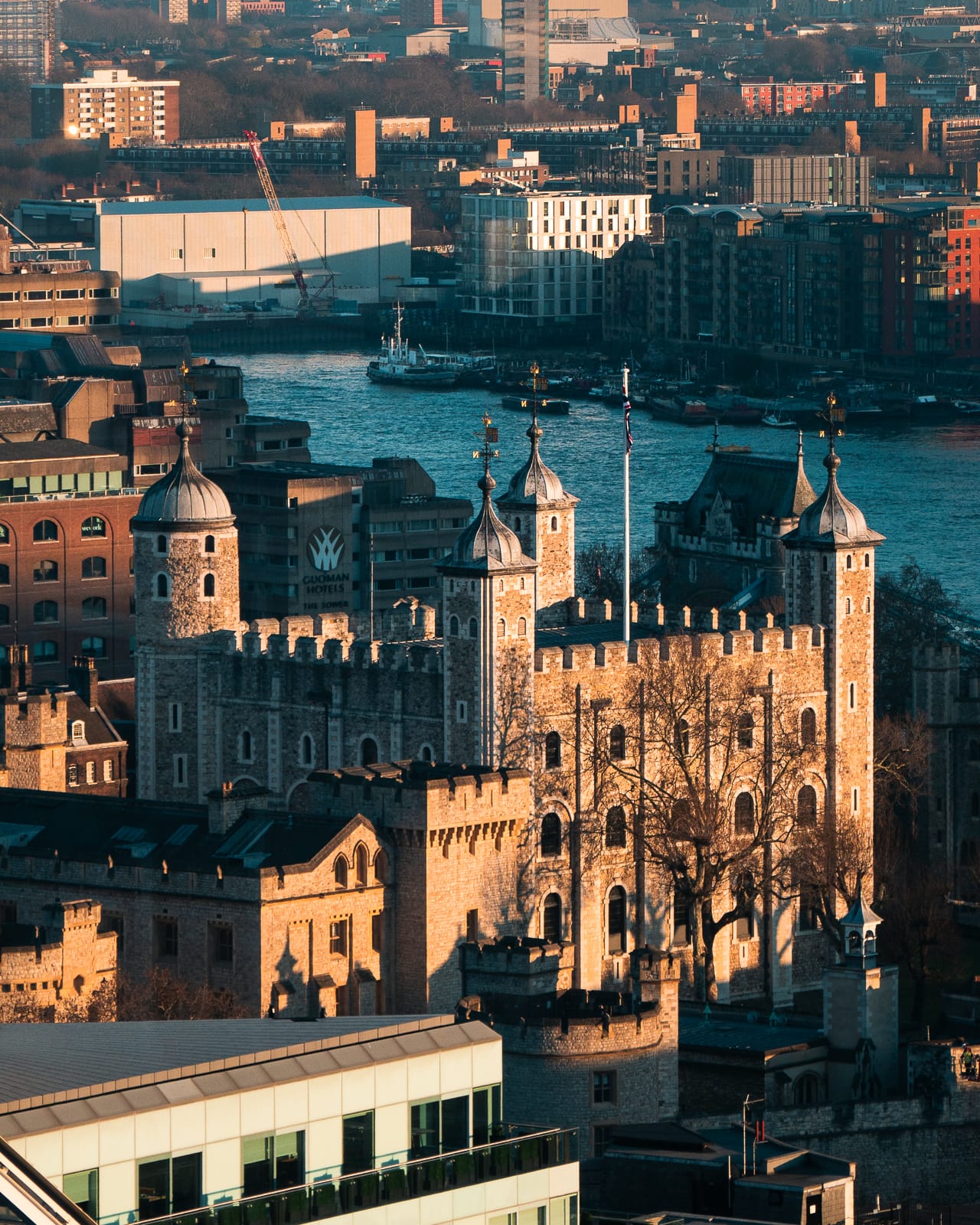 tower of london surrounded by london buildings and river thames 