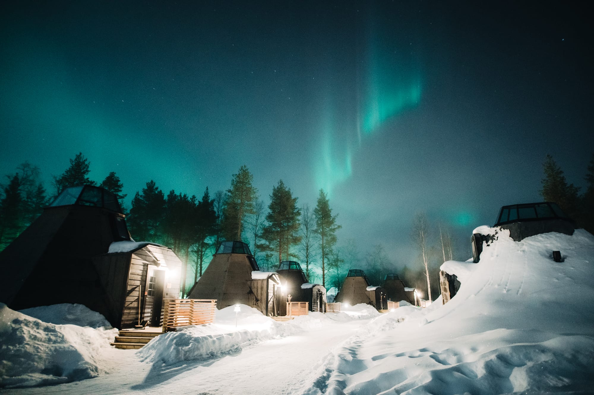 Glass roofed cabins under northern lights at Apukka Resort, Lapland