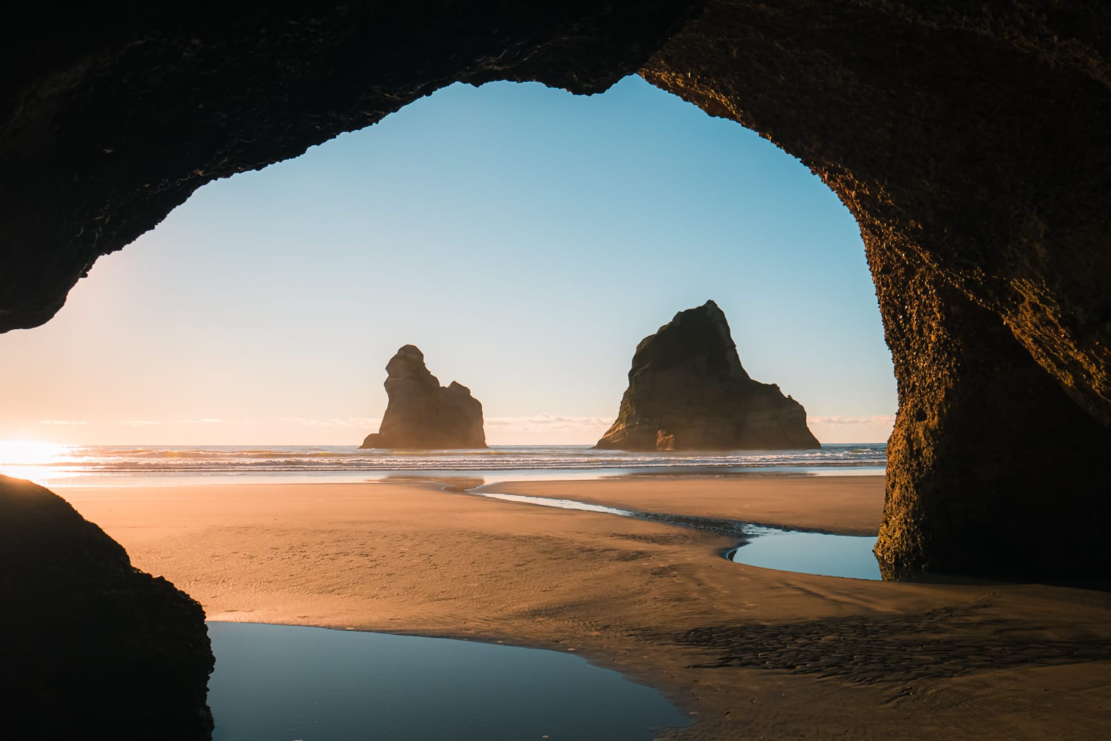 Archway Islands framed by cave at wharariki beach in new zealand 