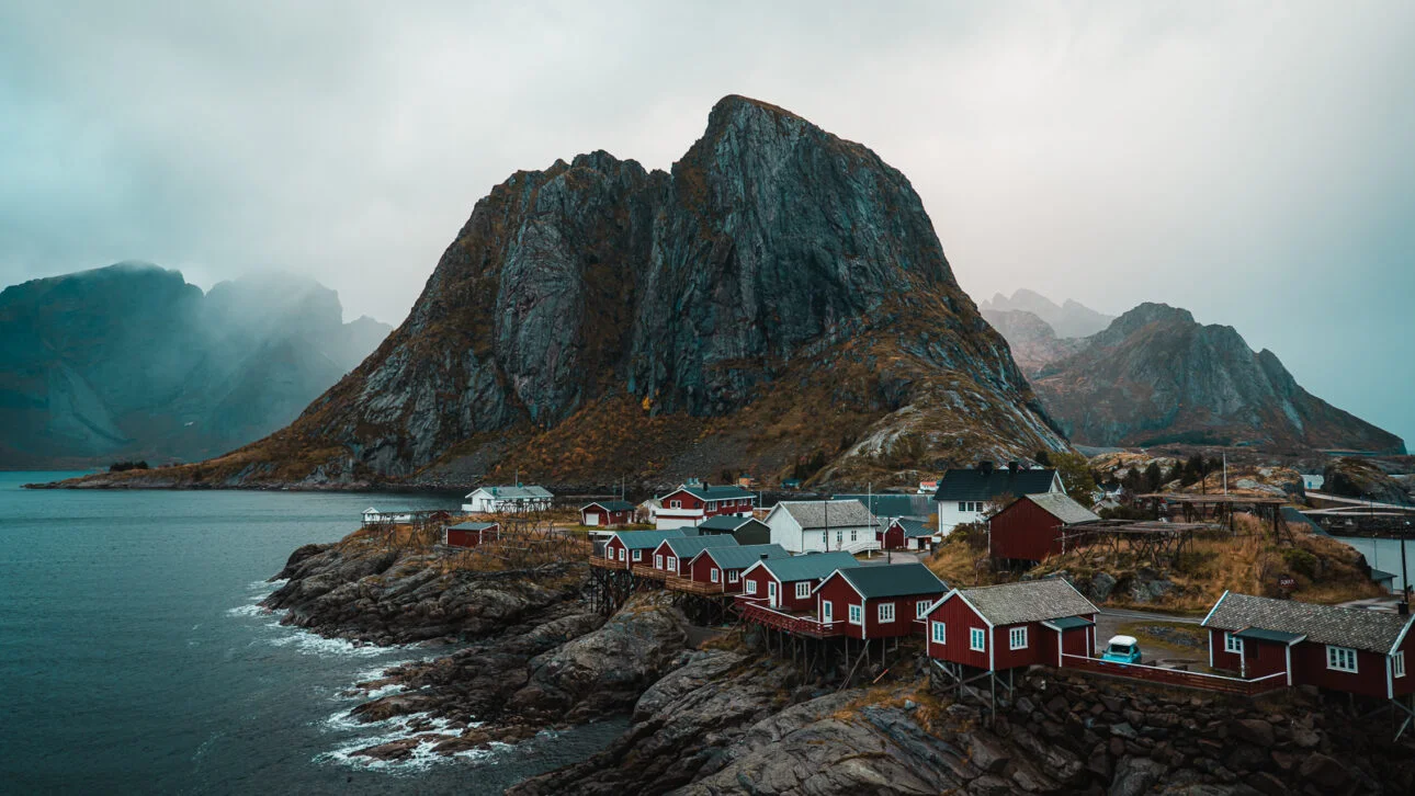 Red fishing cabins with mountain backdrop from Hamnoy bridge, Lofoten Islands, Norway