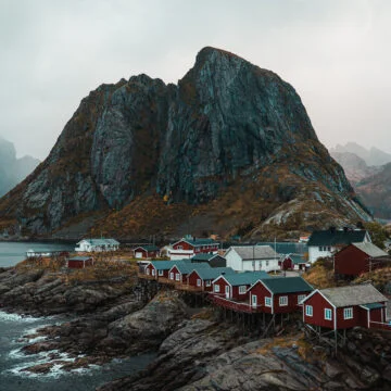 Red fishing cabins with mountain backdrop from Hamnoy bridge, Lofoten Islands, Norway